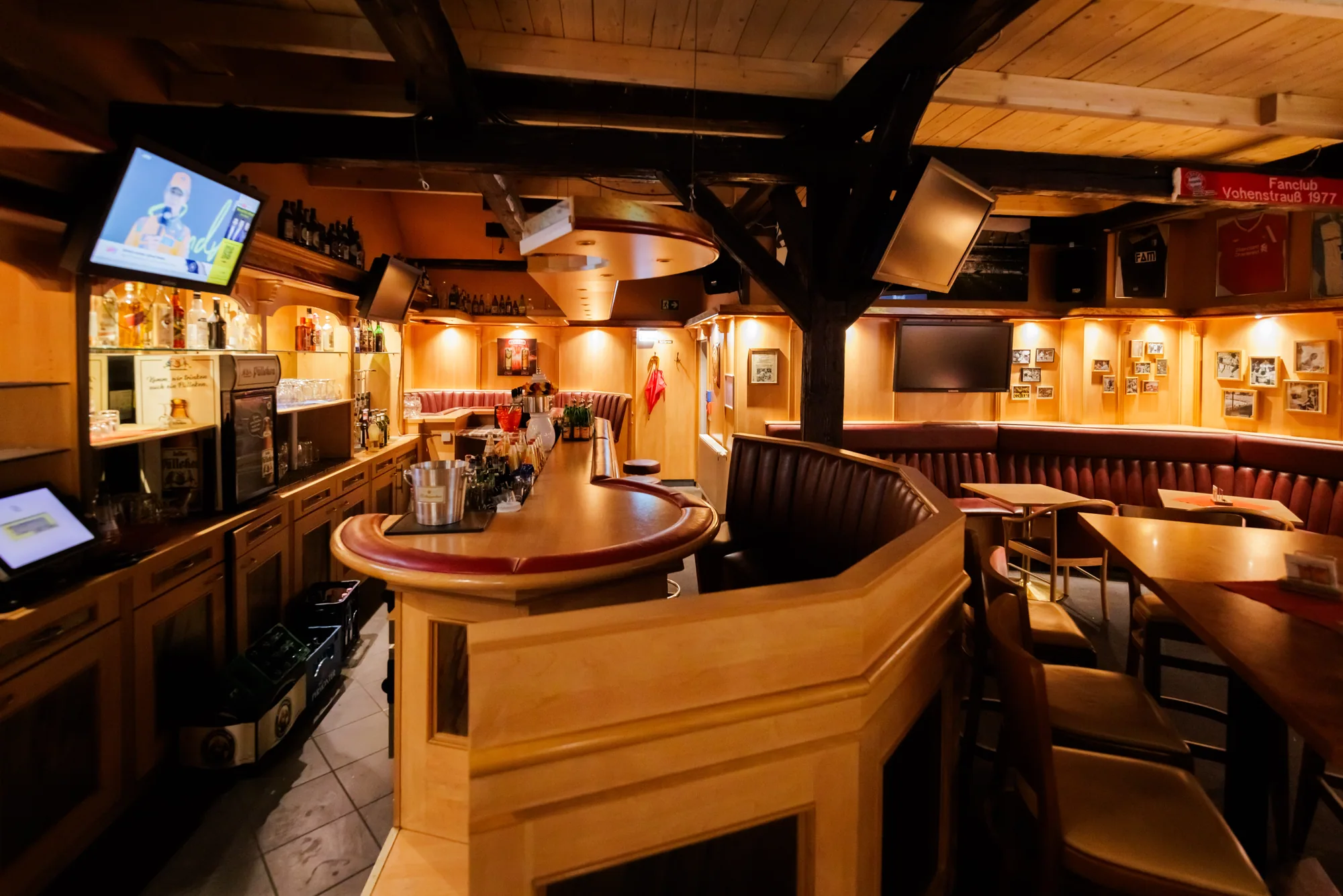 Sportsbar im Brauhaus Wernigerode mit großer Holztheke, Barhockern, Bildschirmen und dunklen Deckenbalken