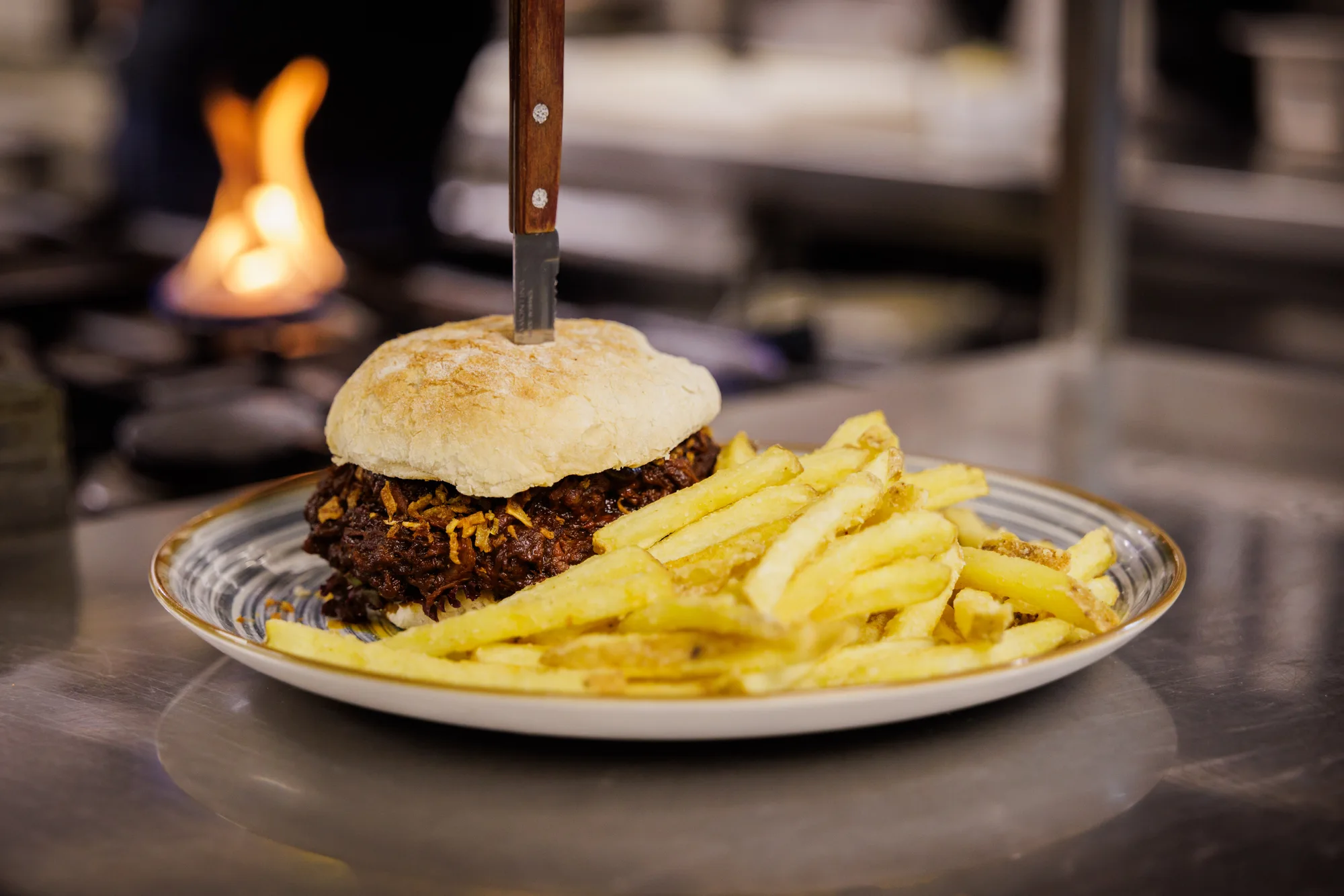 Burger mit Pommes auf einem Teller in der Küche des Brauhauses Wernigerode