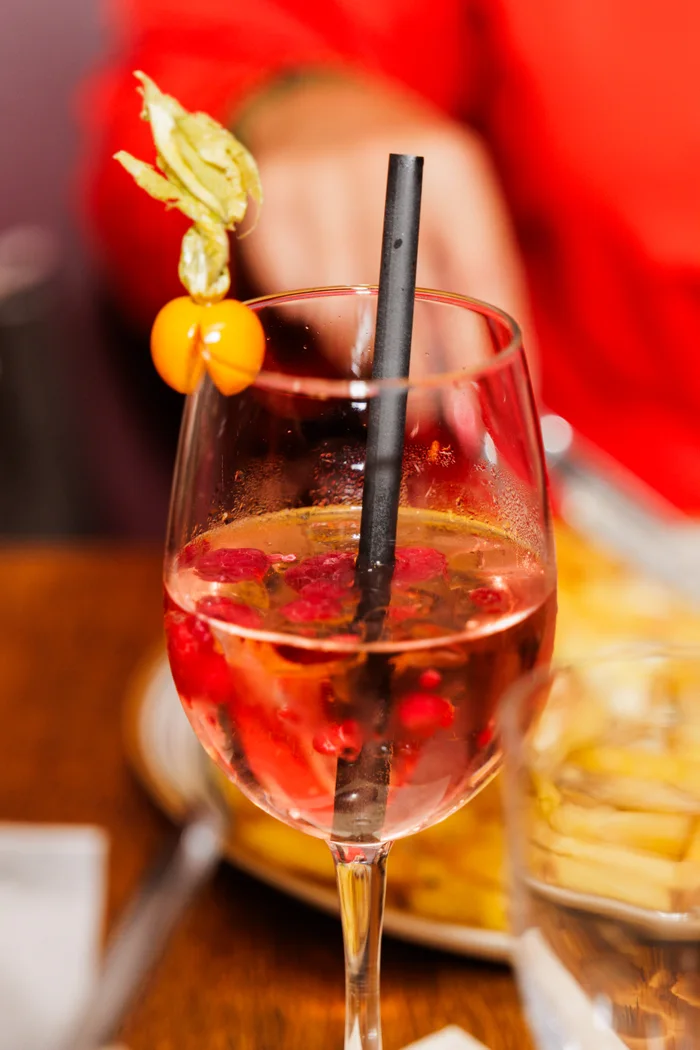 Ein frisch gemixter Cocktail mit Himbeeren und Physalis im Brauhaus